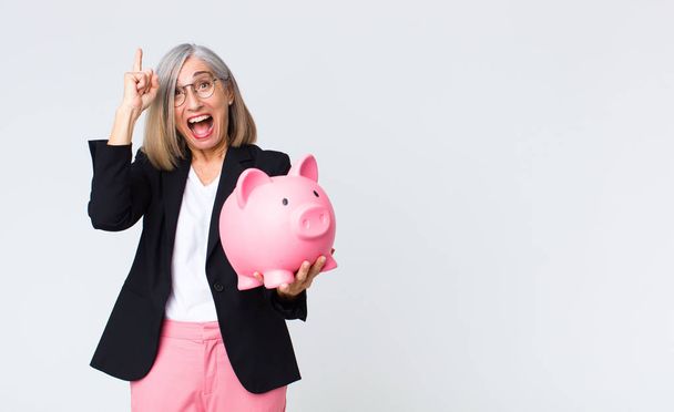 middle age woman with a piggy bank. savings concept - Fotó, kép
