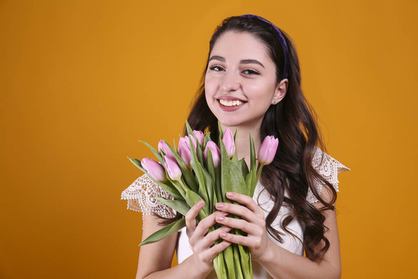 Beautiful female holding bouquet of springtime flowers for international women's day holiday. - Zdjęcie, obraz