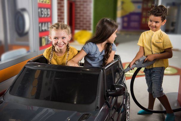 Kids at a gas station. - Фото, изображение