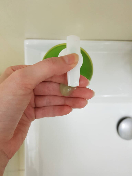 Fingers with green cleanser gel. Female hand push on soap bottle. - Photo, Image