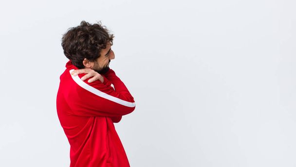 young bearded man back view feeling in love and looking cute, adorable and happy, smiling romantically with hands next to face against copy space wall - Fotoğraf, Görsel