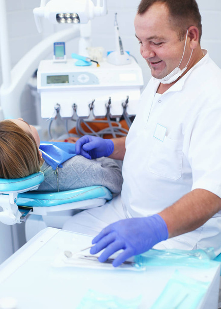 Senior male dentist in dental office talking with female patient and preparing for treatment - Φωτογραφία, εικόνα