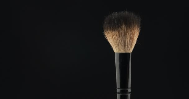 Rotation of a cosmetic brush on a black background. - Кадры, видео