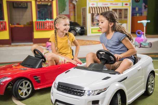 Twee gelukkige kinderen spelen met speelgoed auto 's. - Foto, afbeelding