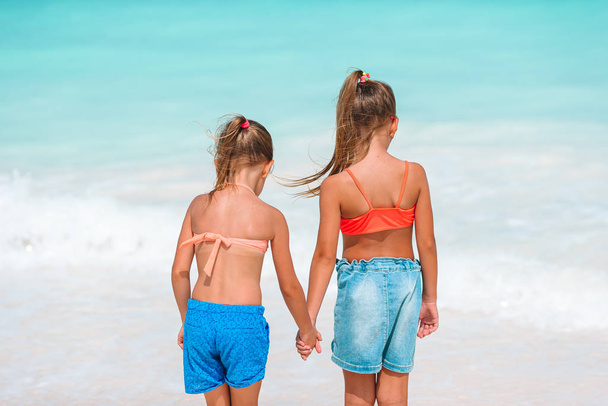 Dziewczynki, zabawy na tropikalnej plaży grając razem w płytkiej wodzie - Zdjęcie, obraz