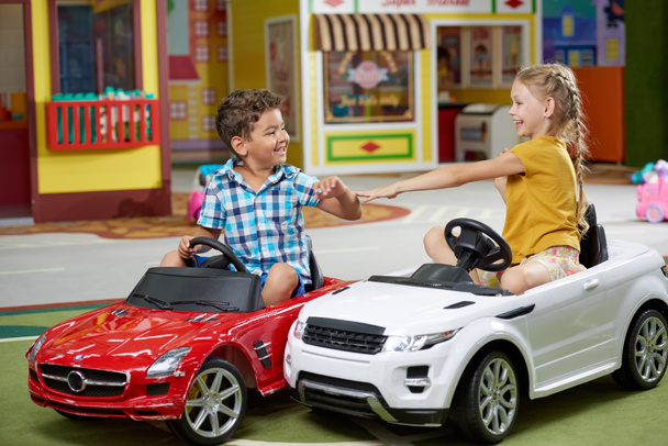 Двоє щасливих дітей грають у великих іграшкових автомобілях
. - Фото, зображення
