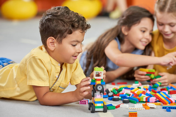 Crianças brincando de brinquedos de bloco na sala de jogos no berçário
. - Foto, Imagem
