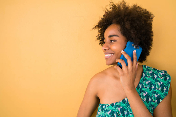 Νεαρή Αφρο γυναίκα μιλάει στο τηλέφωνο. - Φωτογραφία, εικόνα