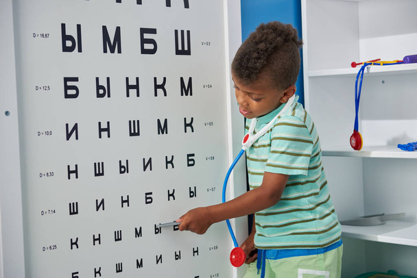 Kid Doctor ellenőrzése betegek látása a szemészet szobában. - Fotó, kép