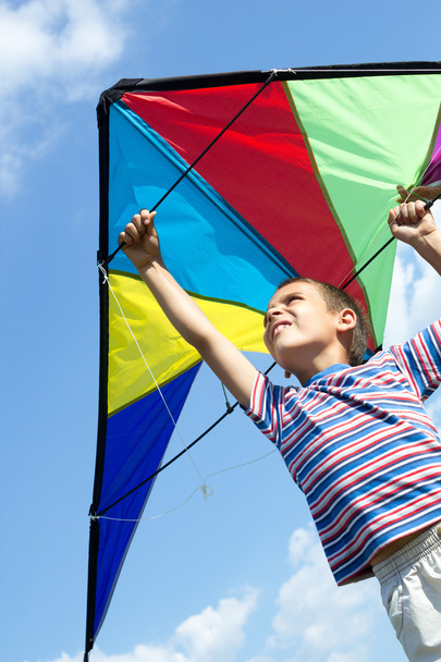 Little boy flies a kite into the blue sky - Fotó, kép