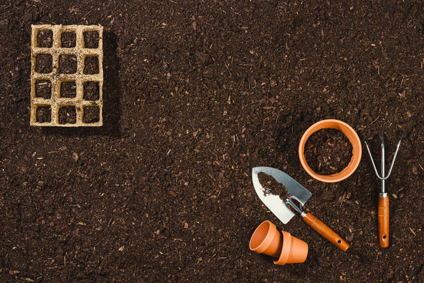 Gardening tools on soil texture background top view. - Fotó, kép