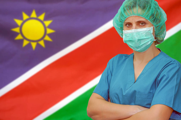 Namibya bayrağının arka planında kadın cerrah. Namibya 'da sağlık, ameliyat ve tıbbi konsept. - Fotoğraf, Görsel