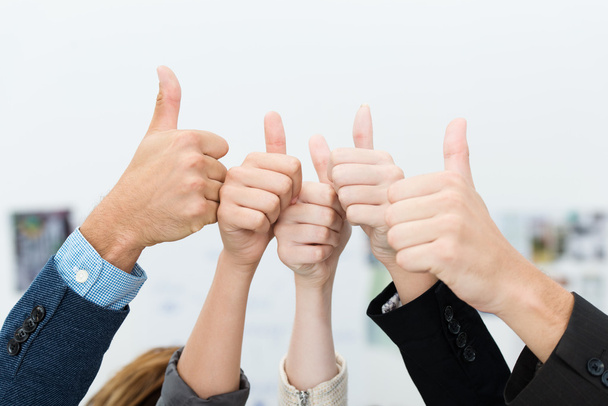 Business team giving a victorious thumbs up - 写真・画像