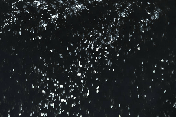 Δυνατή χιονοθύελλα σε μαύρο φόντο. Μπλίζαρντ σε κίνηση θολούρα. - Φωτογραφία, εικόνα
