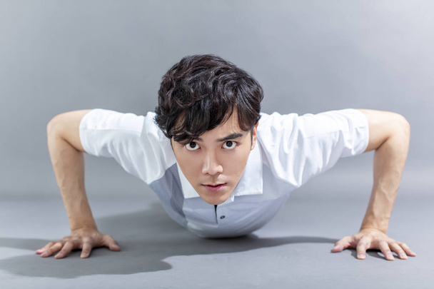 Portret van aziatische fitness man doet push-ups - Foto, afbeelding