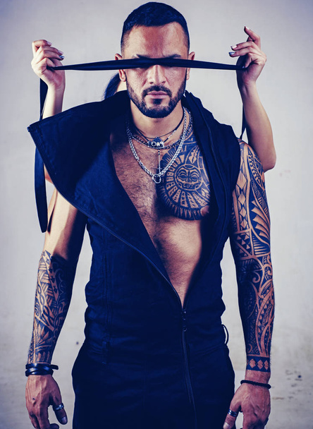 trust concept. muscular macho man with athletic body. brutal sportsman. steroids. dominating. sexy abs of tattoo man. male fashion. female hands cover his eyes with rope. censorship. Human Right day - Фото, изображение
