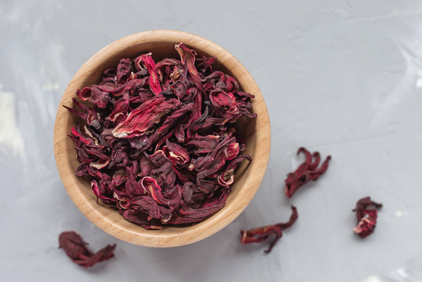Hibiscus tea in wooden bowl on gray background - Photo, Image