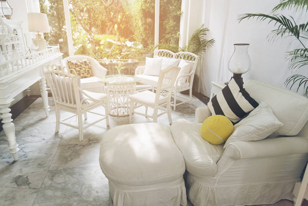 εσωτερική διακόσμηση του σπιτιού Ευρύχωρο, λευκό σαλόνι με καναπέ, καρέκλες, διακοσμήσεις σε κίτρινο, μαύρο και άσπρο χρώμα. Έννοια εσωτερικού. - Φωτογραφία, εικόνα