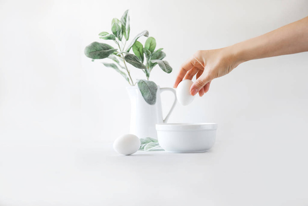 White jug with sage plant, white bowl with eggs on white backgro - Foto, imagen