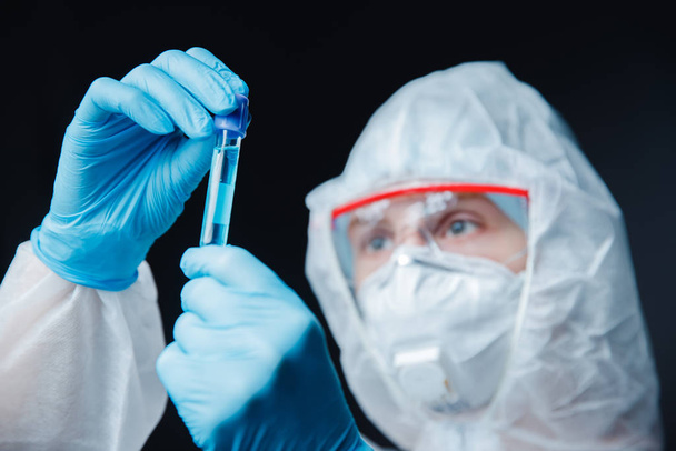 Medical female bioengineer researcher performing scientific test in laboratory, working on development vaccines, drugs in pharmacy. Black background - Zdjęcie, obraz