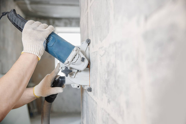 Ouvrier constructeur coupe chasse électrique dans le mur de béton avec circulation scie couronne de diamant perceuse - Photo, image