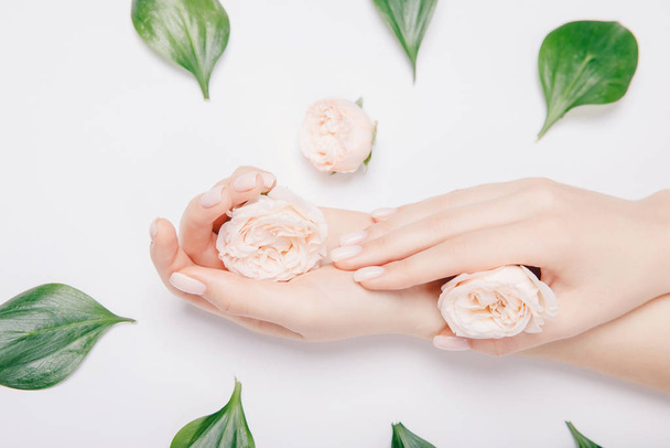Beautiful stylish trendy female pink manicure with flower on background, top view. Concept bio nature cosmetics skin care - Fotografie, Obrázek
