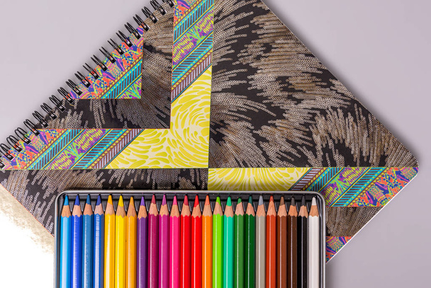 Na skicáku je krabice s ořezávanými barevnými tužkami. Položky kreativity. - Fotografie, Obrázek