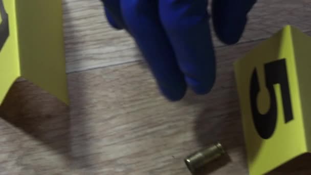 Kriminalbeamter in blauen Handschuhen, verpackte Patronen in einer Tasche, zur Untersuchung am Tatort - Filmmaterial, Video