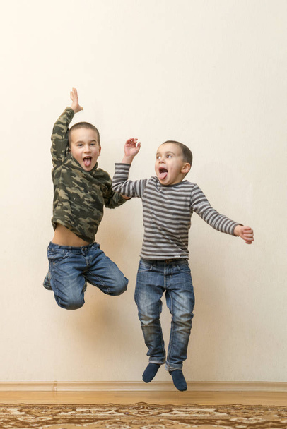 Kaksi poikaa leikkimässä yhdessä kotona. Liikkuvuus ja ihmisten käsite
. - Valokuva, kuva