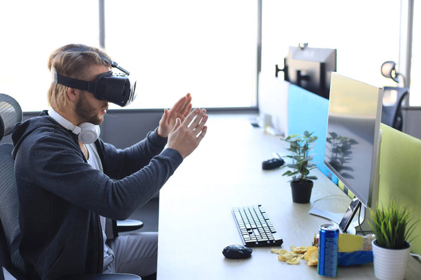 Молодой бородатый мужчина в очках виртуальной реальности в современном стиле
 - Фото, изображение