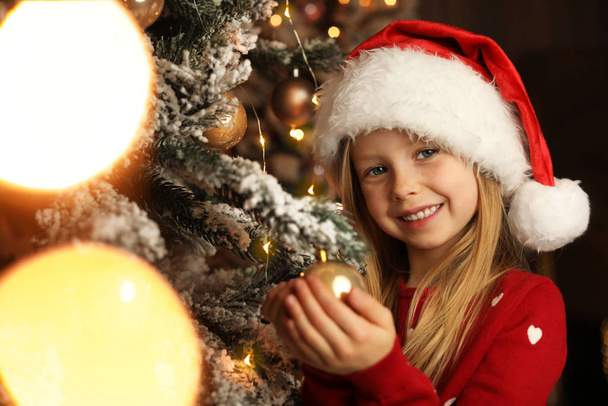 Cute little child near Christmas tree at home - Φωτογραφία, εικόνα