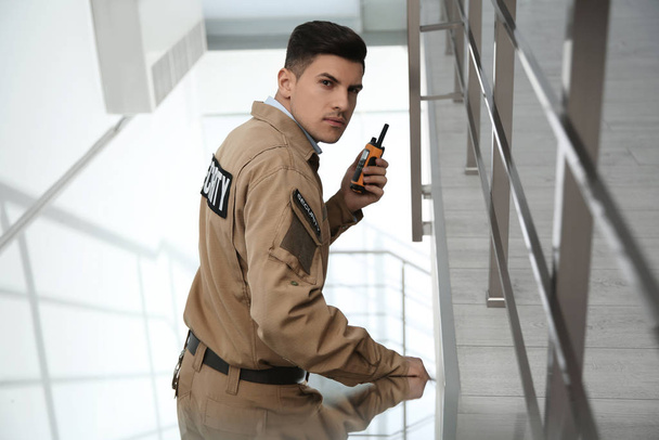 Professional security guard with portable radio set on stairs - Foto, Bild