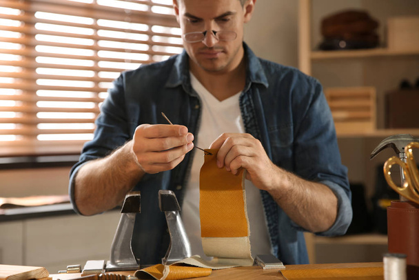 Man sewing piece of leather in workshop, focus on hands - Foto, Imagem