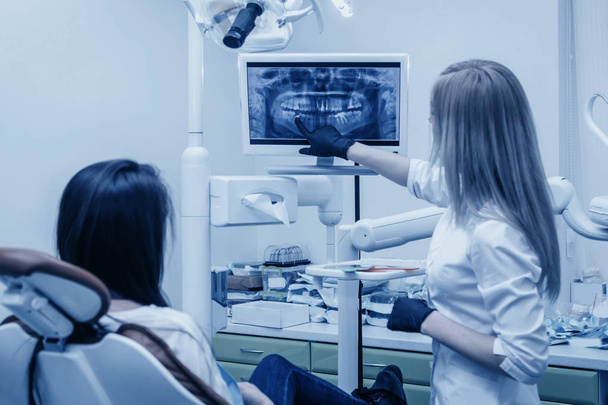 girl dentist shows on roentgen to patient - Photo, Image
