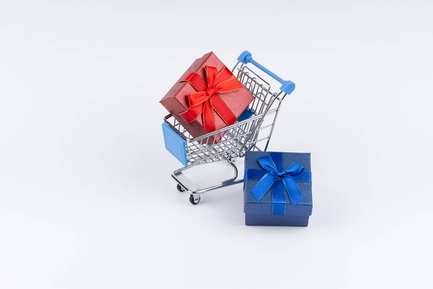 Shopping cart with presents on white background - 写真・画像