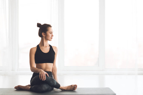 Slim girl practicing yoga looking at free space - Photo, Image