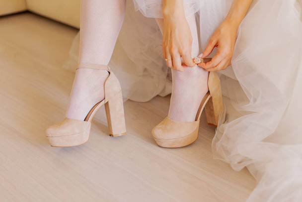 Молодая невеста закрывает обувь в счастливый день свадьбы
. - Фото, изображение
