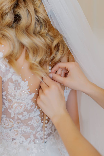 A young bride buttoned wedding dress. Happy wedding day. - Photo, image