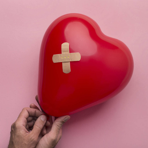 Vrouw met gebroken hartballon met verband - Foto, afbeelding