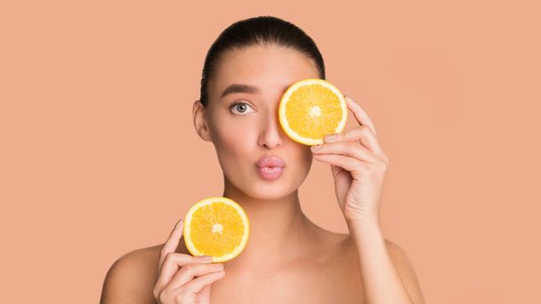 Natural spa. Beautiful woman holding pieces of orange - Photo, image