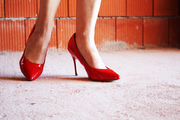 jambes de femme avec des chaussures à talons rouges dans une maison inachevée
 - Photo, image