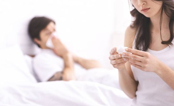 Young wife reading medication instruction for her sick husband - Photo, Image