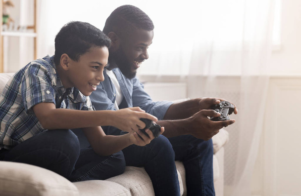 Ojciec i syn Afro grają w gry wideo z joystickami - Zdjęcie, obraz