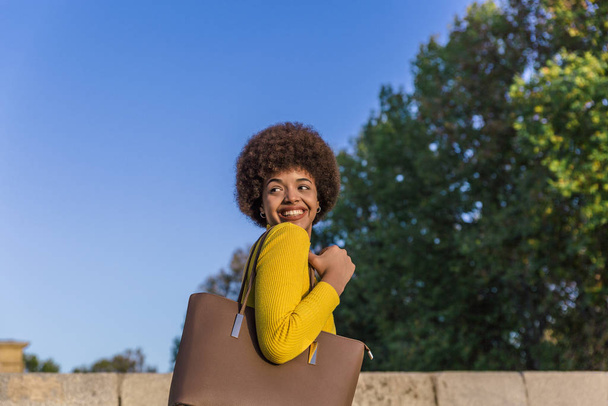 Mixed Race Model mit Afro-Haaren lächelt glücklich mit einem breiten Lächeln im Freien einen schönen sonnigen Tag - Foto, Bild