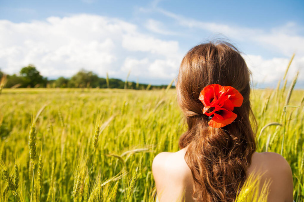 Красива дівчина стоїть з нею спиною в білій сукні в пшеничному полі
 - Фото, зображення