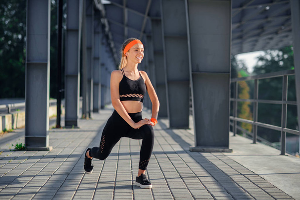 squatting. beauty girl do exercises at the stadium in the morning - Photo, Image