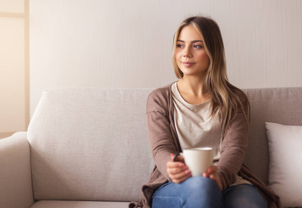 Millennial girl drinking hot coffee at home - Foto, Bild