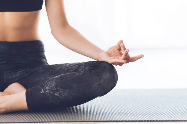 Slim girl practicing yoga sitting on mat - Foto, imagen