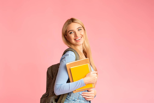 Teenager wearing backpack holding notebooks at studio - Fotoğraf, Görsel