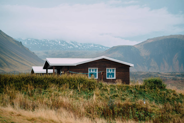 Typisches skandinavisches Holzhaus gegen die Berge. Island. - Foto, Bild